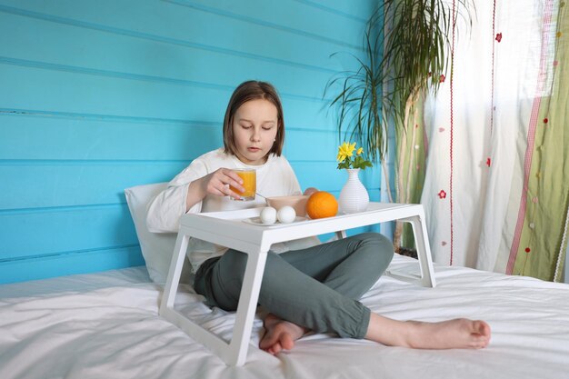 La niña desayuna en la cama