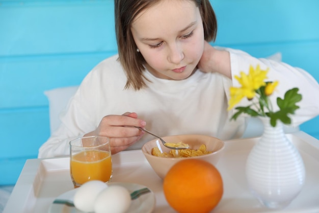 La niña desayuna en la cama