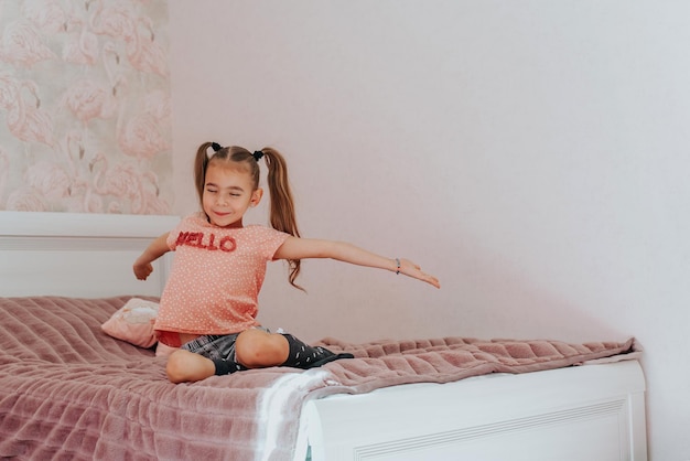 una niña se despierta después de dormir en su cama