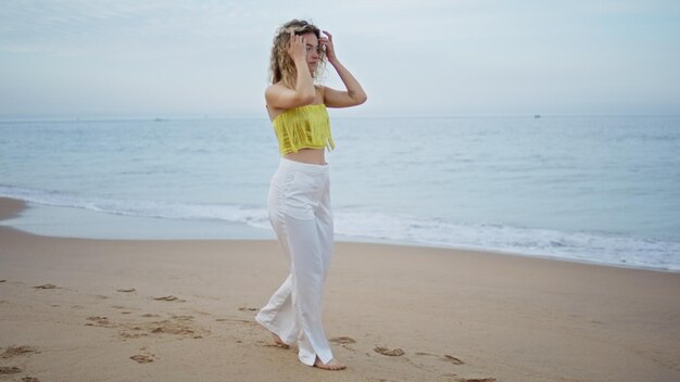 Niña despreocupada caminando por la playa sola mirando la vista del océano mujer pisando la arena húmeda