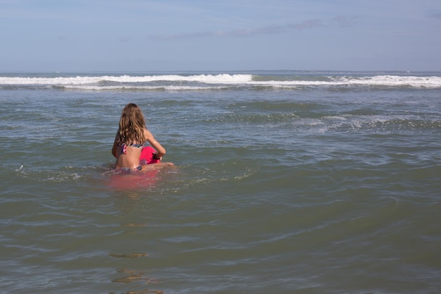 niña detrás de la playa de mar de agua