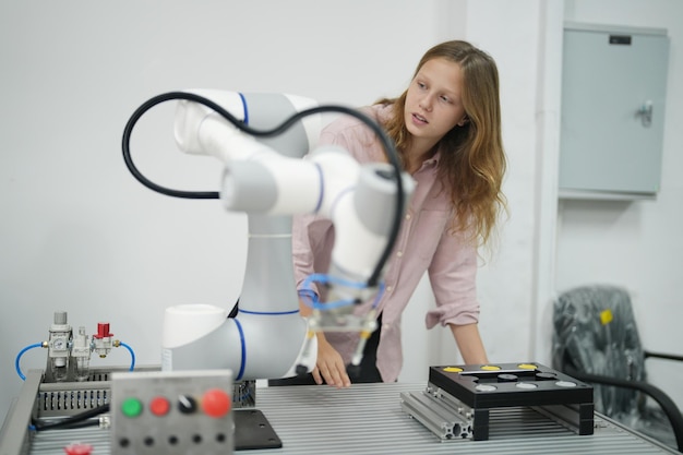 Una niña se para detrás de un robot que dice 'robot'