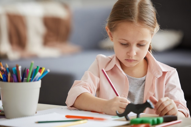 Niña dibujando con lápices de colores