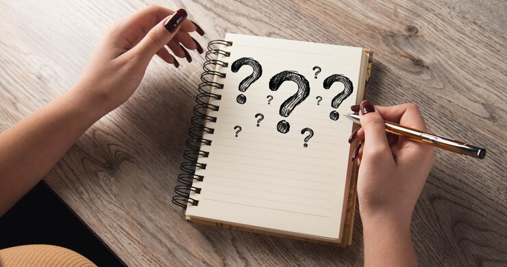 Foto la niña dibujó signos de interrogación en un cuaderno.