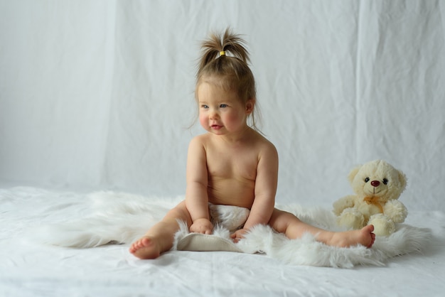 Niña de diez meses está jugando con un juguete