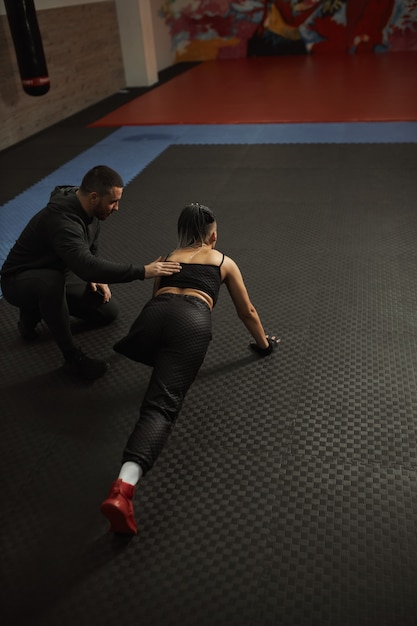 Una niña discapacitada participa en el gimnasio Una mujer con una pierna entrena con un entrenador, trabaja duro y no se rinde ante los problemas