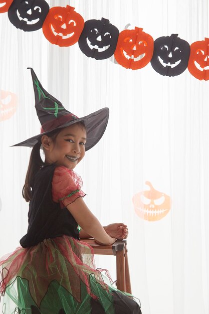 Foto niña con disfraz de bruja durante halloween