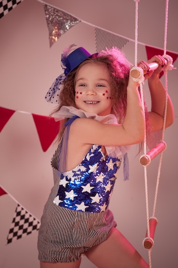 Niña con disfraz de circo en el escenario del circo.