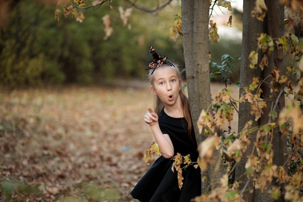 niña en un disfraz de halloween en el bosque