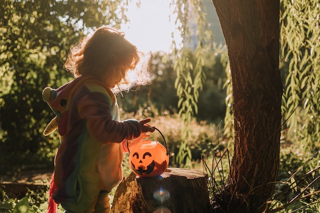 Niña en un disfraz de Halloween de unicornio arcoíris fabuloso maravilloso bosque mágico