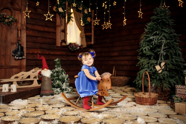 Una niña disfruta montando un caballito mecedor que le regalaron por Navidad.