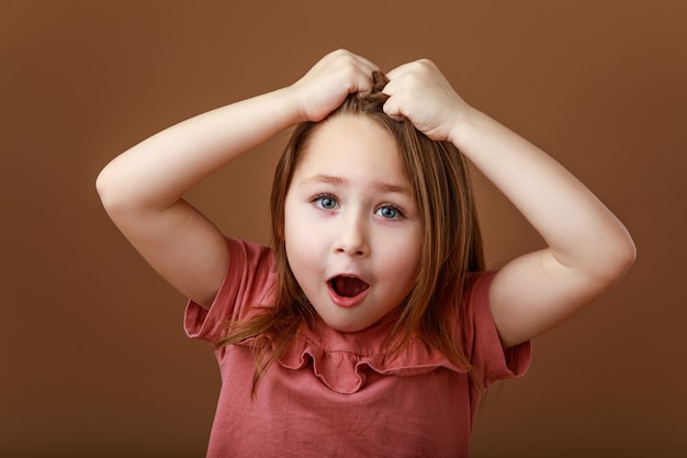 Foto niña divertida agarrándose la cabeza con sorpresa