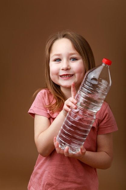 Niña divertida con una botella de agua