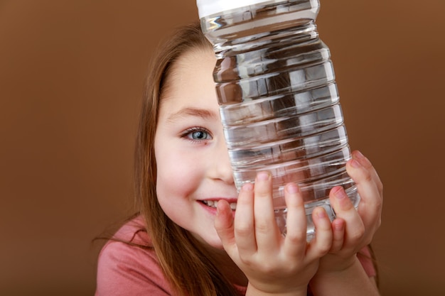 Niña divertida con una botella de agua