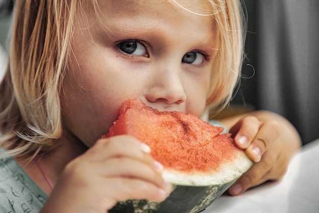 Niña divertida comiendo sandía closeup Niño lindo con sandía en el interior Concepto de comida saludable verano Copiar espacio