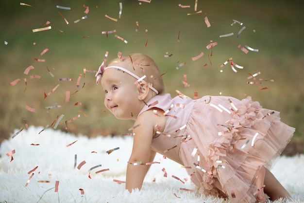 Una niña divertida en un confeti brillante Niño celebra un año Hermoso bebé