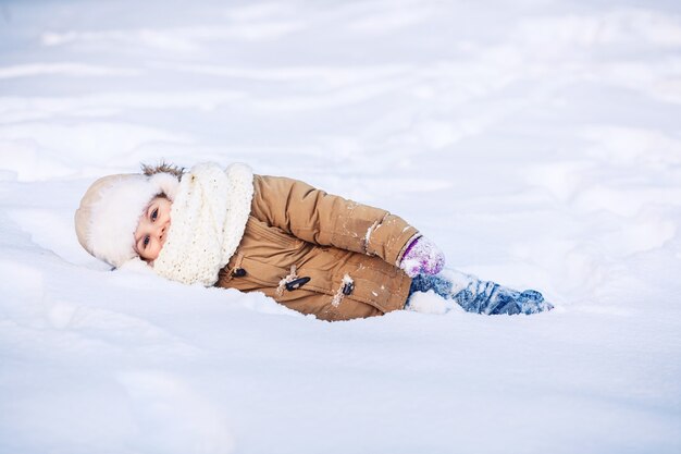 Niña divertida en el invierno en la nieve.