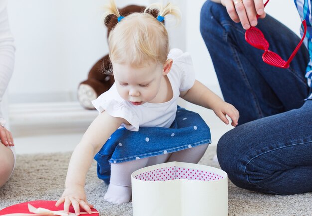 Niña divertida del niño del bebé que juega en la sala de estar. Concepto de familia y niños.