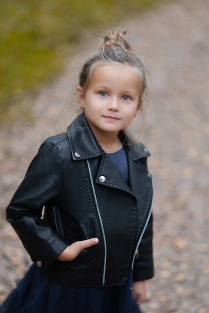 Niña divertida en el parque en día de otoño