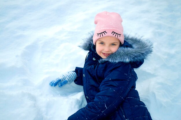 La niña se divierte jugando el día de invierno en ventisquero