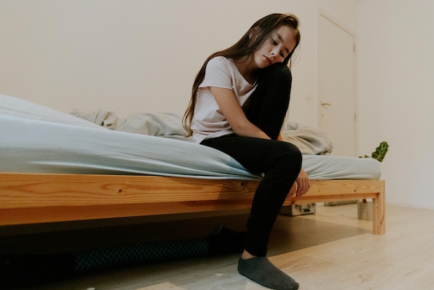 Niña dormida sentada en la cama de la habitación