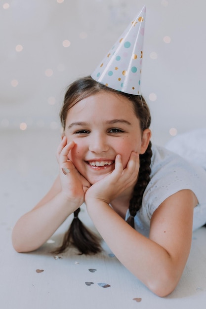 Niña con dos coletas en un vestido blanco celebra su cumpleaños