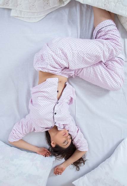 Niña duerme en una cama blanca en casa