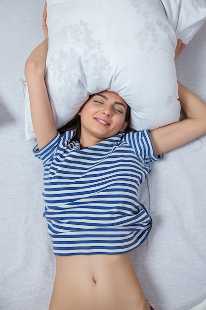 Niña duerme en una cama blanca en casa