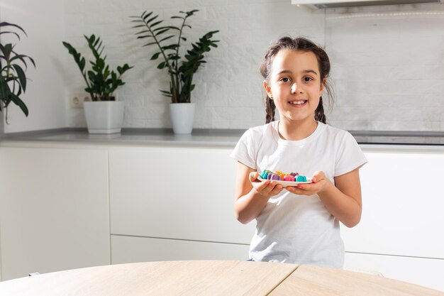 niña con dulces caseros de colores.