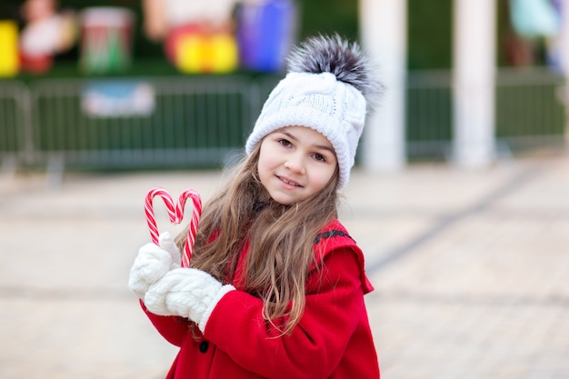 Niña con dulces navideños al aire libre