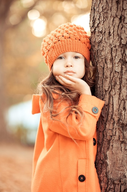 Niña elegante con chaqueta de otoño de moda y gorro de punto al aire libre