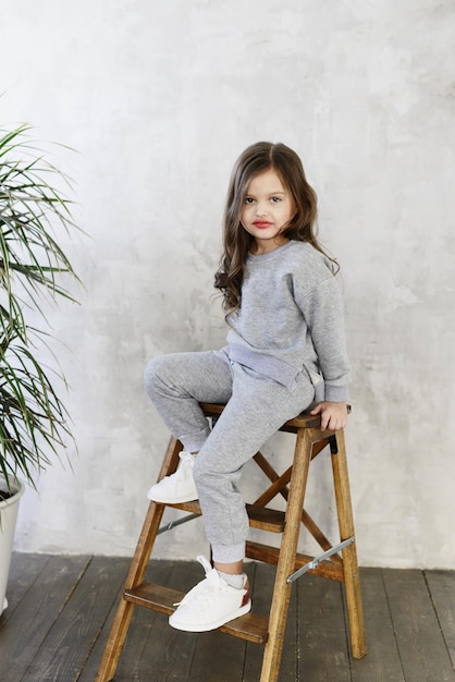 Niña elegante en un traje gris