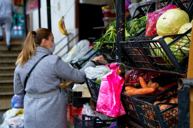 Una niña elige productos en un mostrador de verduras de la calle.