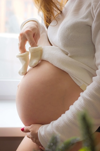 Niña embarazada con botines esperando un bebé