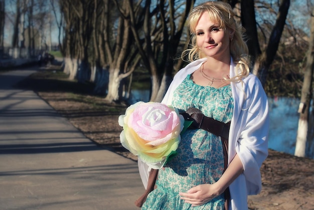 Niña embarazada está caminando por el parque de la ciudad a principios de la primavera