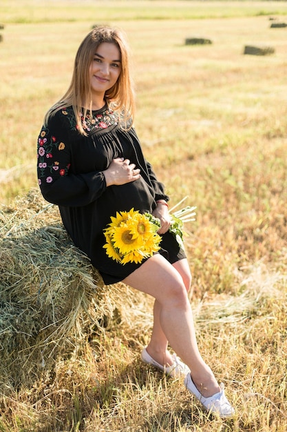 Niña embarazada en girasoles niña feliz esperando al bebé