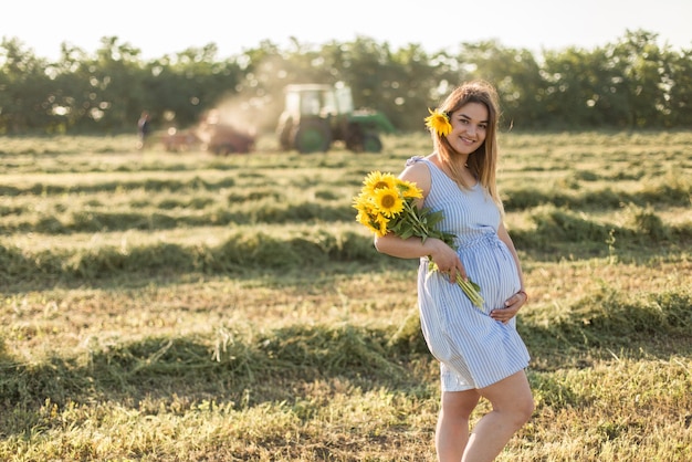 Niña embarazada en girasoles niña feliz esperando al bebé