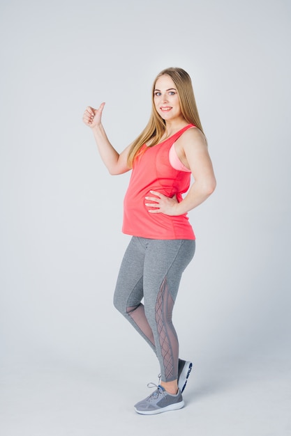 Niña embarazada en ropa deportiva se dedica a la aptitud