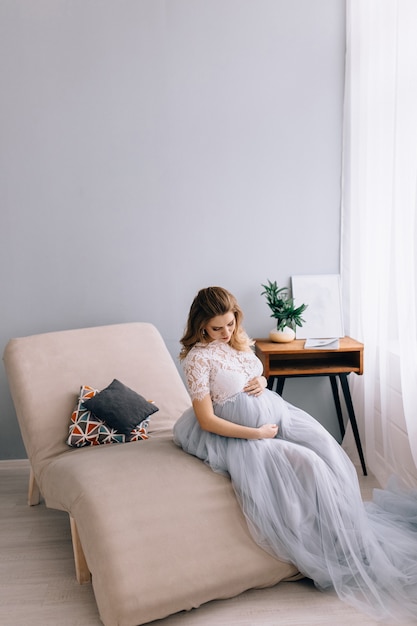 Niña embarazada sentada en una silla decorada