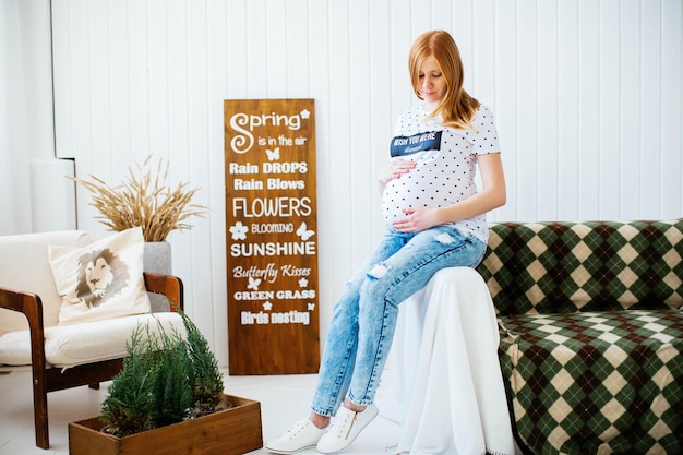 Niña embarazada en el sofá Maternidad Esperando al niño Embarazo