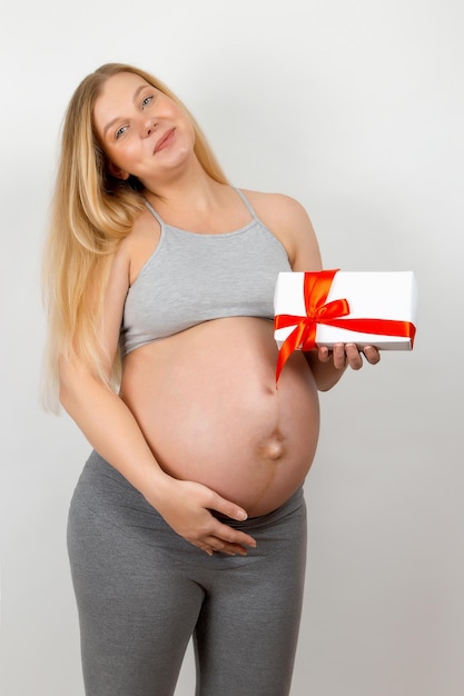 Una niña embarazada sostiene un regalo El nacimiento de una remenka es el mejor regalo