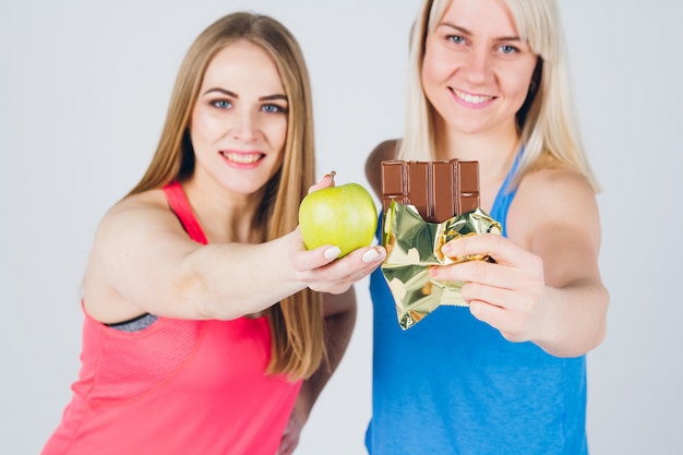 Niña embarazada y su amiga comen manzana y chocolate