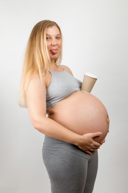 Una niña embarazada con un vaso de café Cafeína el beneficio o daño para el bebé