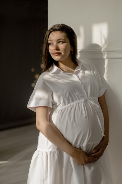 Niña embarazada con un vestido blanco con peonías.