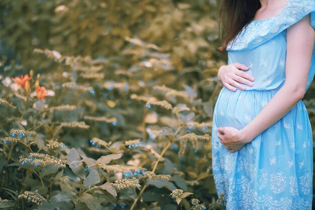 Niña embarazada con un vestido en la naturaleza en un paseo