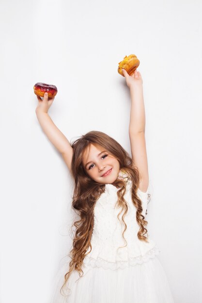 Niña emocionada posando con donas