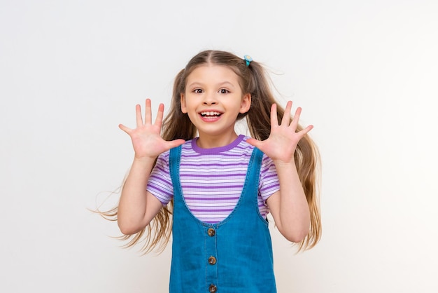 Una niña emocional y alegre sobre un fondo blanco aislado