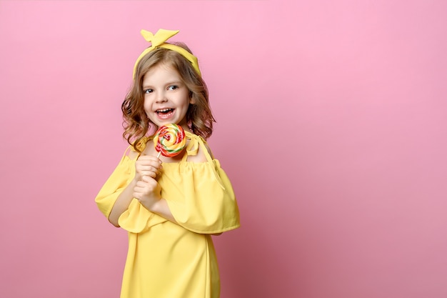 Niña encantadora con dulces en rosa