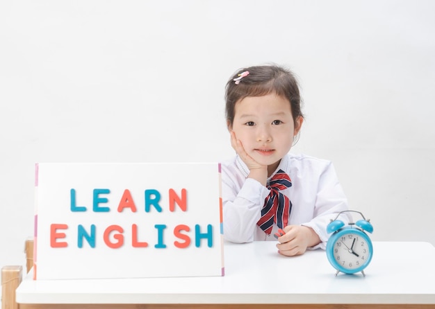 La niña encantadora está aprendiendo letras.