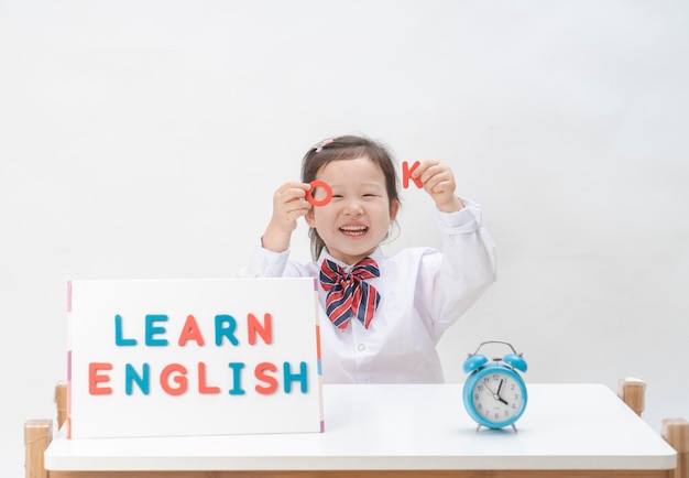 La niña encantadora está aprendiendo letras.